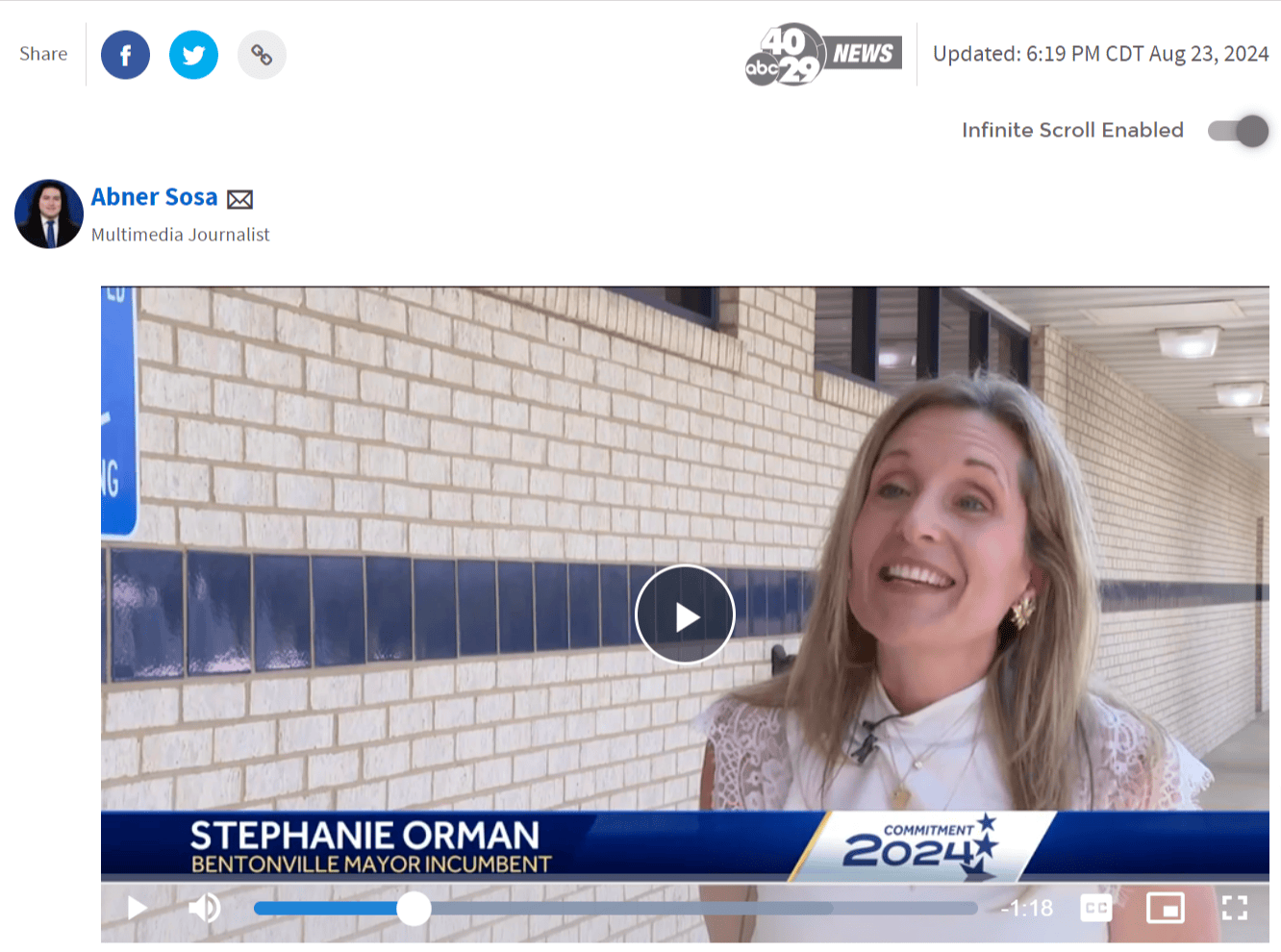 A woman with long hair smiles while being interviewed outside a brick building. A news chyron identifies her as Stephanie Orman, Bentonville Mayor Incumbent.
